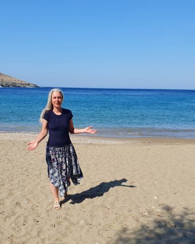 Verena steht am Strand vor dem Meer